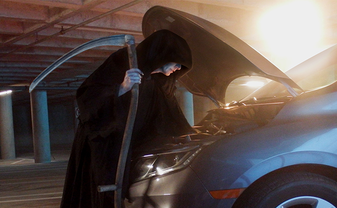 Grim reaper taking battery out of car